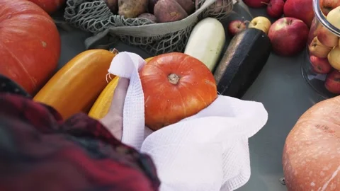 Women's hands wipe pumpkin with a white towel on the market. Top view. Hygiene. Stock Footage 139057796