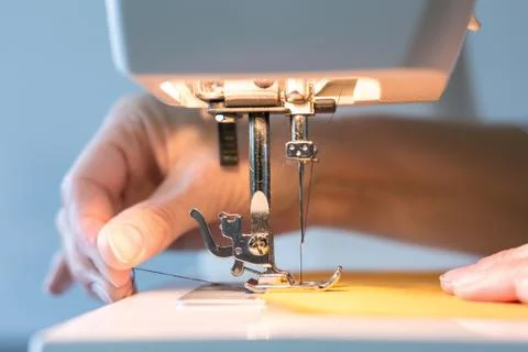 Women's hands at work with the sewing machine Stock Photos
