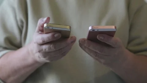 Women's hands work on two smartphones at the same time. Stock Footage 143654435