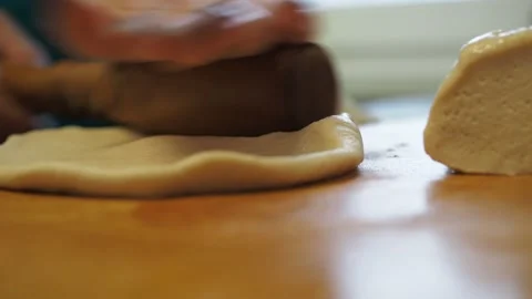 Women's hands wrap and roll out the yeast dough. cooking pies in the kitchen Stock Footage 148035837