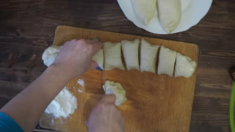 Women's hands wrap and slice the yeast dough. cooking pies in the kitchen Stock Footage 148102908