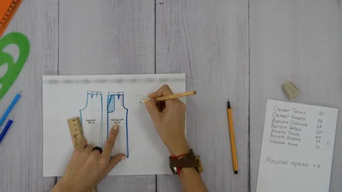 Women's hands write an explanation for the scheme of trousers Stock Footage 89218543