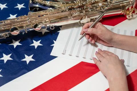 Women's hands write notes on a sheet, on the American flag Stock Photos