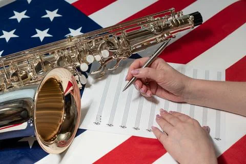 Women's hands write notes on a sheet, on the American flag Stock Photos