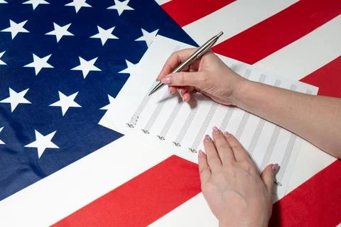 Women's hands write notes on a sheet, on the American flag Stock Photos