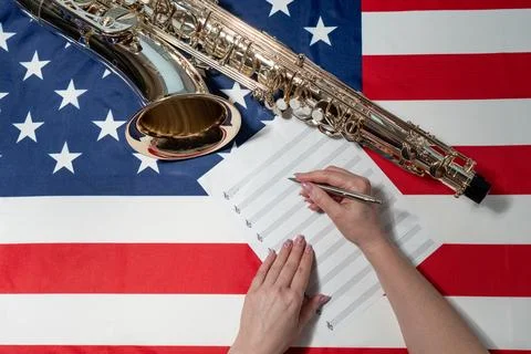 Women's hands write notes on a sheet, on the American flag Stock Photos