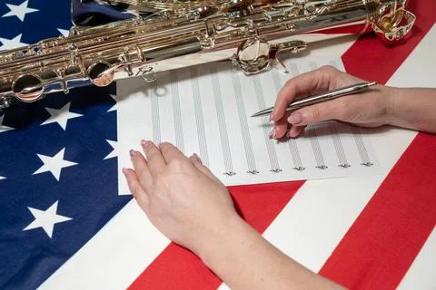 Women's hands write notes on a sheet, on the American flag Photos