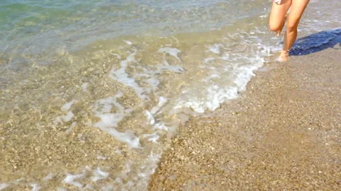 Women's legs run along the seashore Stock Footage 95948844