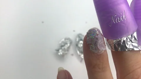 Womens nail in plastic reusable cap clip for soak-off UV gel polish removal. Stock Footage 117675629