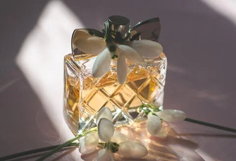 Women's perfume in bright sunlight with spring flowers Stock Photos