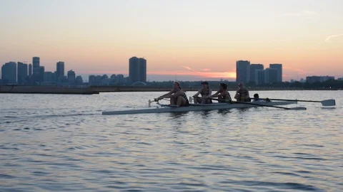 Women's quad rowing team training on lake Stock Footage 88833219