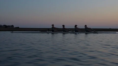 Women's quad rowing team training on lake Stock Footage 88834297