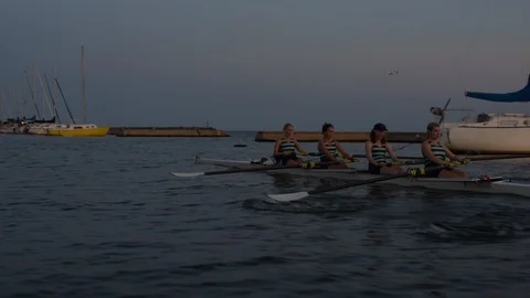 Women's quad rowing team training on lake Stock Footage 88834418