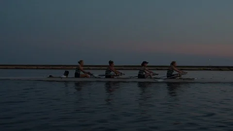 Women's quad rowing team training on lake Stock Footage 88837633