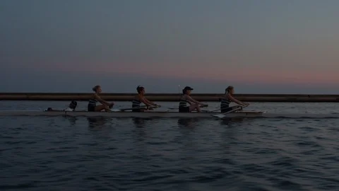 Women's quad rowing team training on lake Stock Footage 88838040