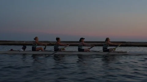 Women's quad rowing team training on lake Stock Footage 88838090