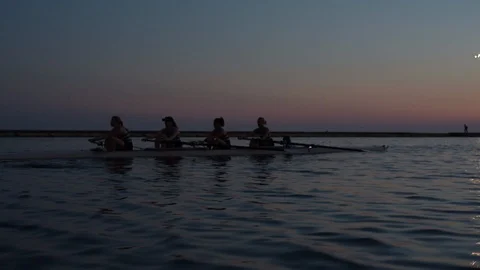 Women's quad rowing team training on lake Stock Footage 88839124