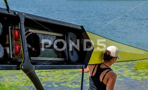 Women's rowing team carries a boat on its shoulders Stock Photos