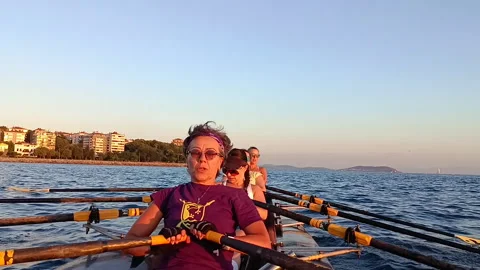 Women's rowing team paddling in sync on the open water Vidéo 329830927