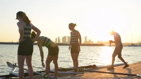 Women's rowing team preparing boat for training at dockside. 库存影片 88833406