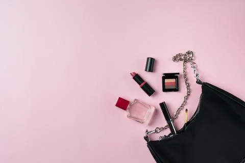 Women's things fall out of a bag on a pink background Stock Photos