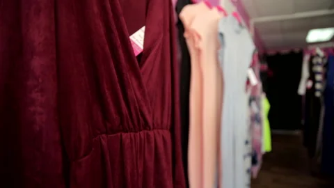Women's tops hang on rack in small shop Stock Footage 236708039