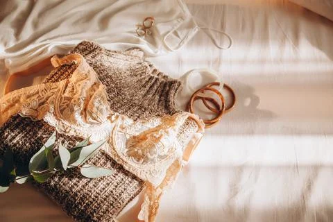 Women's winter wardrobe: lace bra, silk top, coarse knit sweater and accessor Stock Photos
