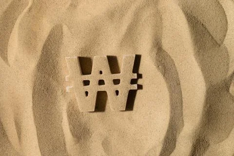 Won Symbol Under the Sand Foto stock