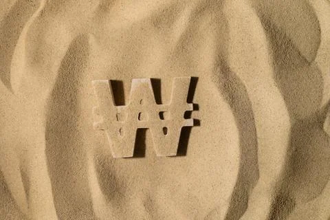 Won Symbol Under the Sand Stock Photos