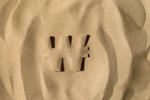 Won Symbol Under the Sand Stock Photos