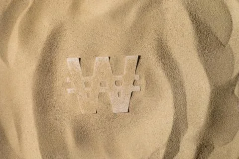 Won Symbol Under the Sand Stock Photos