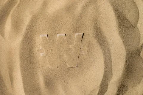 Won Symbol Under the Sand Stock Photos