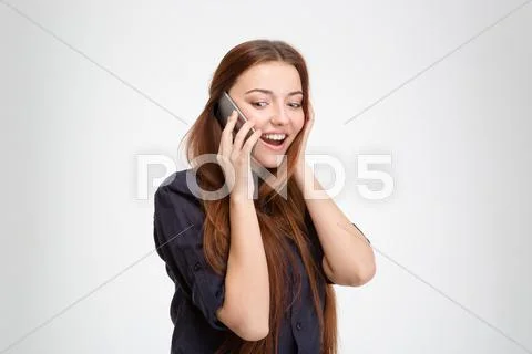 Wondered Happy Young Woman Standing And Talking On Mobile Phone