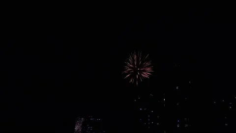 Wonderful bright colourful firework explosion on dark night sky over big city Vidéo 147371388