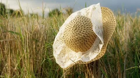 A wonderful close-up of a straw hat with white ruffles fluttering in the wind on Stock Photos