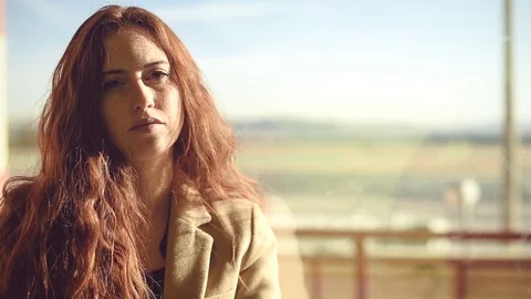 Wonderful redhead model in bright sunlight at the airport Stock Footage 86469723