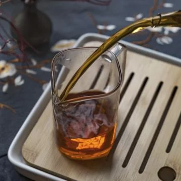 A wonderfully refreshing scene where tea is expertly poured into a beaker filled Stock Photos