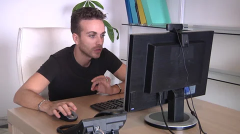 Wondering and amoused man working on PC with webcam. Видео 31612463