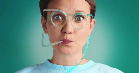 Wondering woman drinks using drinking straw glasses with blue liquid Stock Footage 76549855