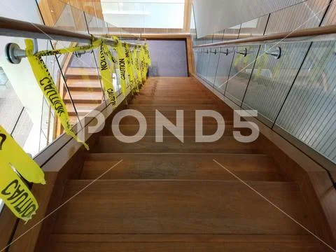 Wood and glass staircase with caution tape Stock Photos