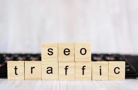 Wood block cube shape put the front computer keyboard with word SEO TRAFFIC and Stock Photos