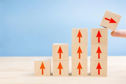 Wood block cubic stacking step up with RED Arrow Blue background. Business gr Stock Photos