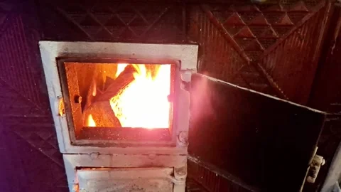 Wood Burning Fire Glowing Inside an Old Metal Stove in Rustic Interior Video stock 347597727