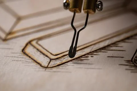 Wood burning tool creating pyrography pattern on wooden board Stock Photos