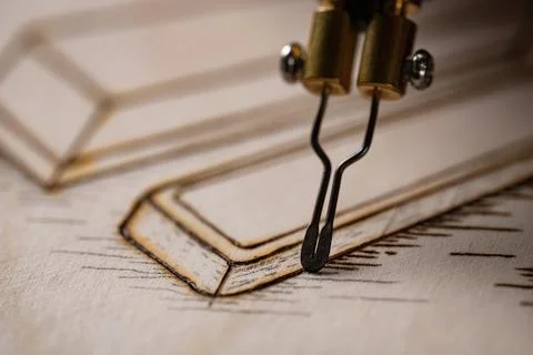 Wood burning tool creating pyrography pattern on wooden board Stock Photos