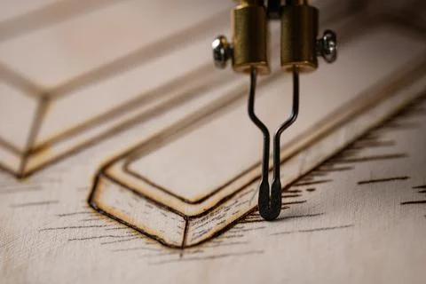 Wood burning tool creating pyrography pattern on wooden board Stock Photos