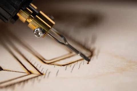 Wood burning tool creating pyrography pattern on wooden board Foto stock