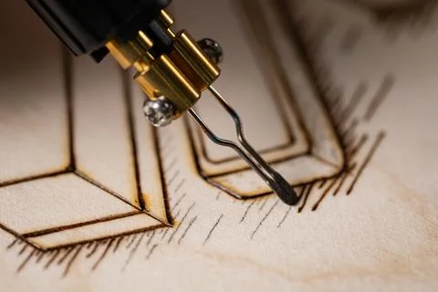 Wood burning tool creating pyrography pattern on wooden board Stock Photos