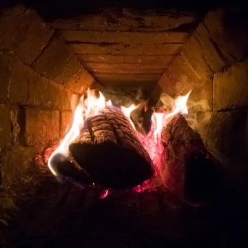 Wood burns inside the old rustic stove. Stock Photos