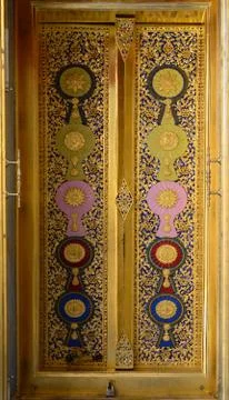 The wood carving door panels with painted royal insignias on a door panel. Stock Photos